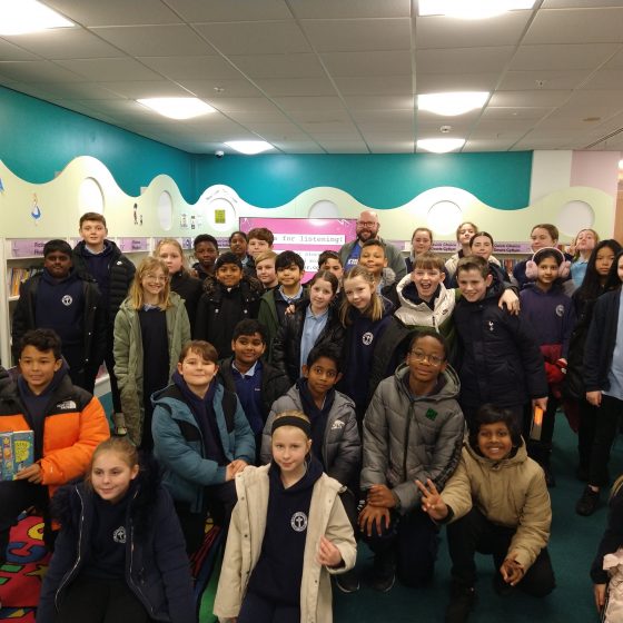 Pupils from St Joseph's Primary School, standing with P.G. Bell in Port Talbot Library.